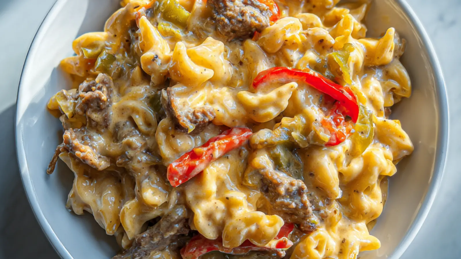 Creamy Philly cheesesteak mac and cheese with tender beef, peppers, and rich cheese sauce