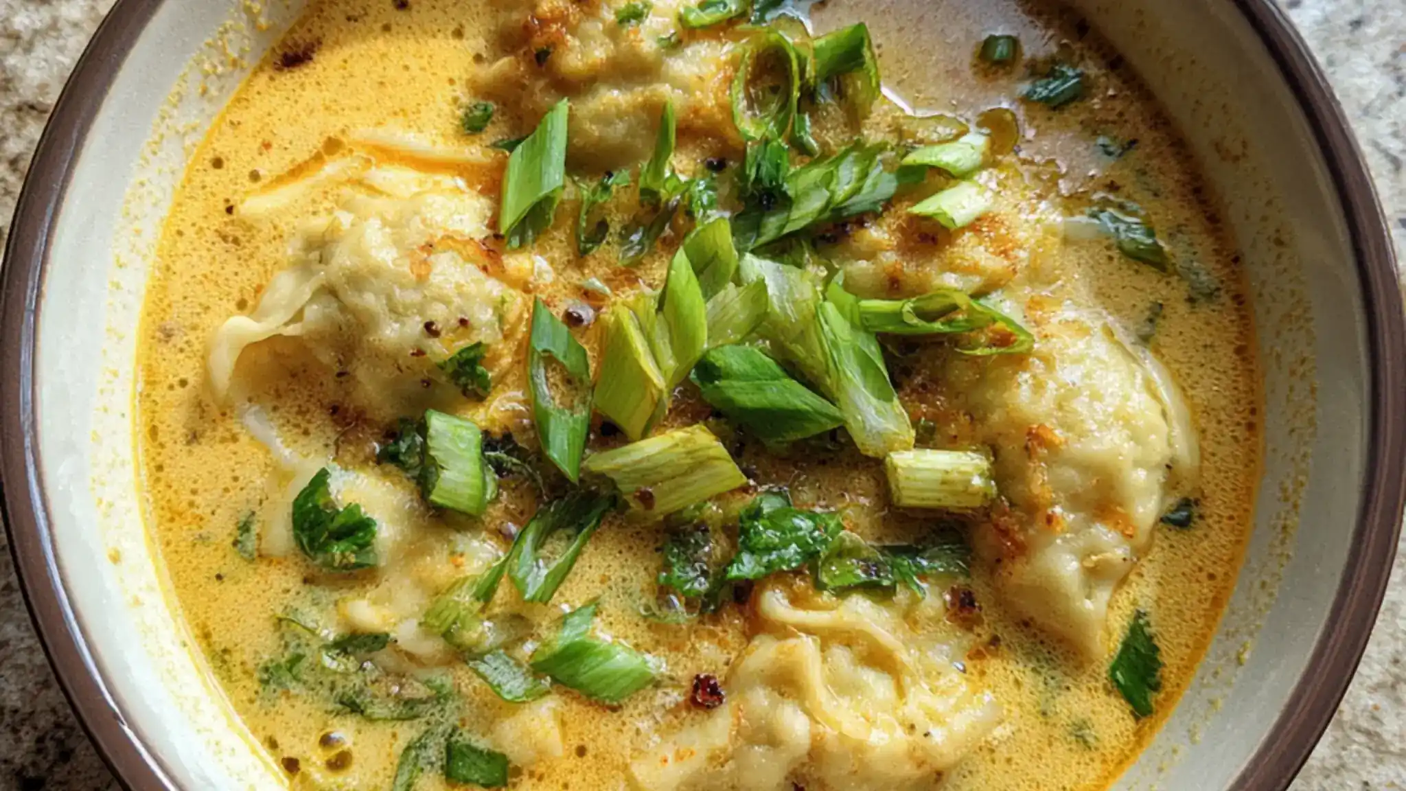Coconut curry dumpling soup with creamy broth and green onions