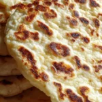 Cottage cheese flatbreads stacked on a plate with golden toasted spots
