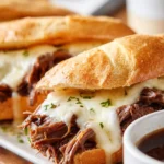 French dip sandwiches with melted cheese and shredded beef served with au jus dipping sauce