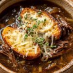 French onion beef short rib soup topped with melted cheese and toasted baguette slices