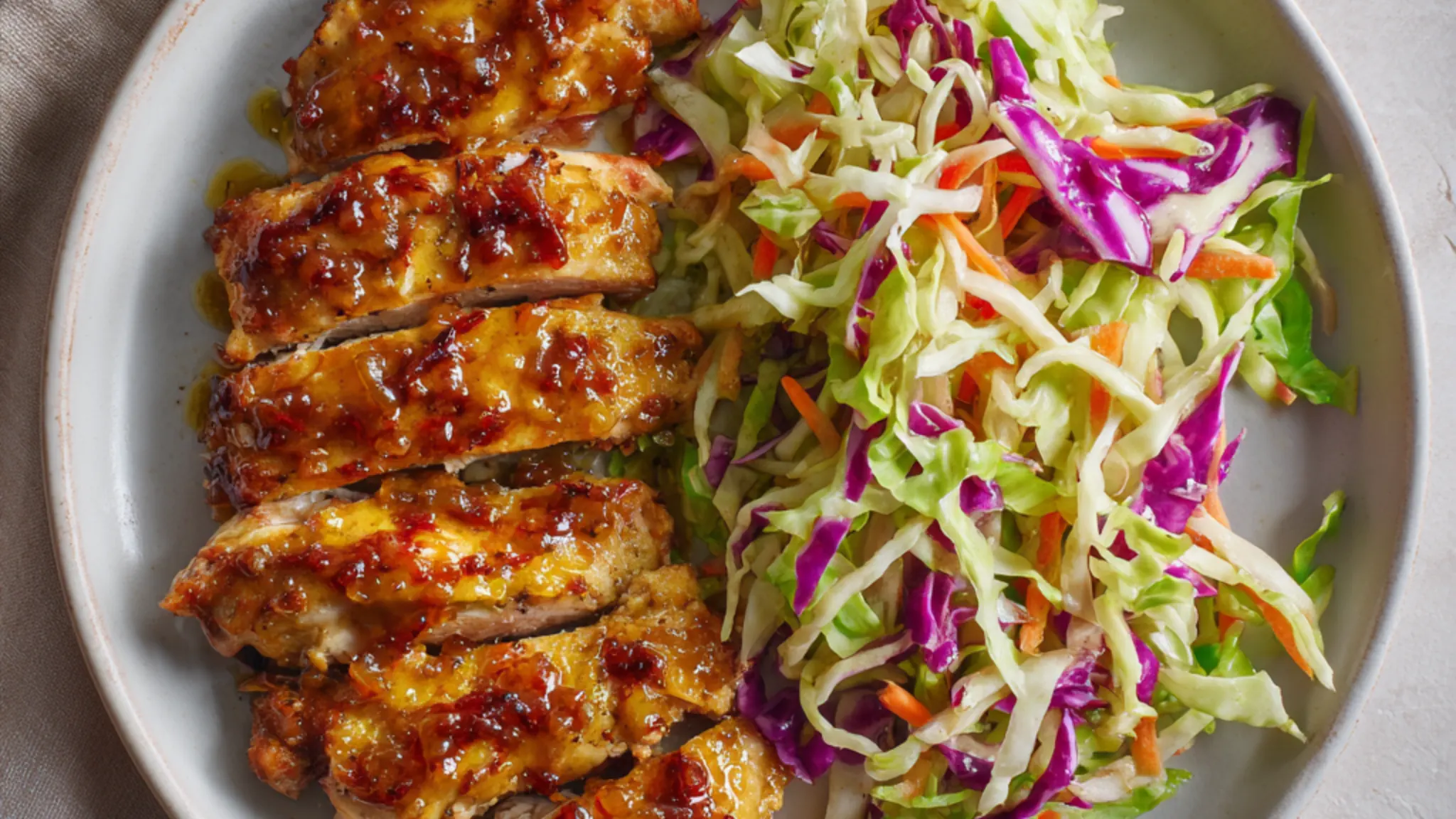 Low carb glazed chicken thighs served with crunchy cabbage slaw