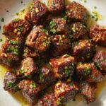 garlic butter steak bites with herbs on plate