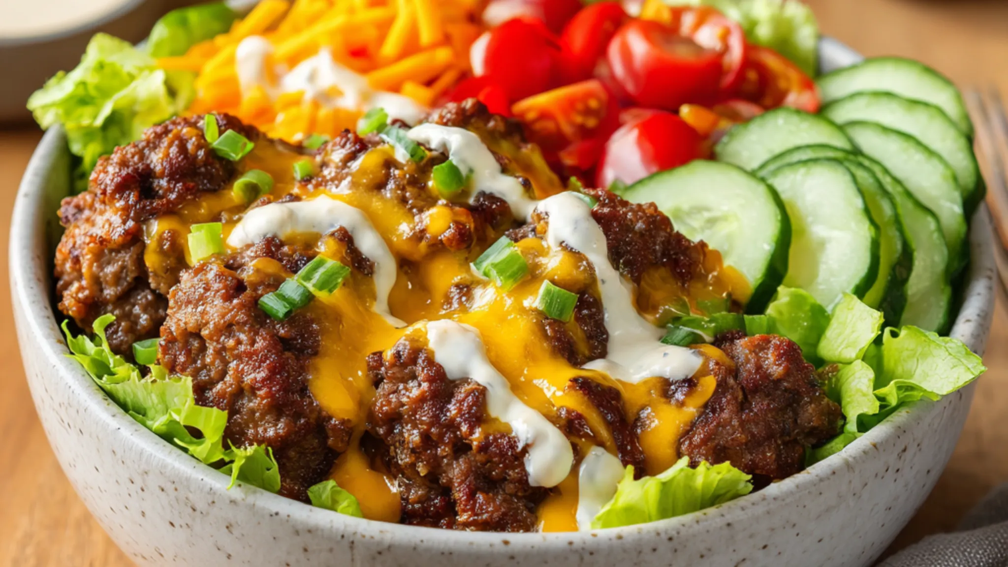 smash burger bowl with beef, cheese, lettuce, tomatoes and cucumbers